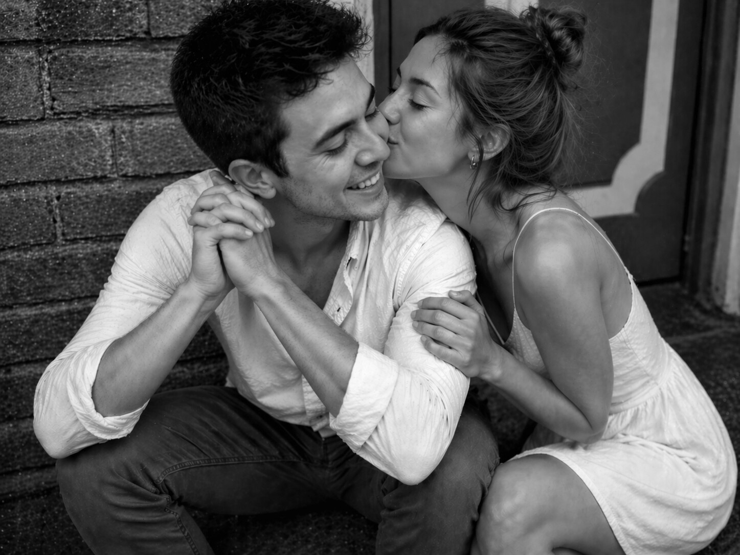 Una pareja joven en un momento de cariño compartiendo un beso en la mejilla